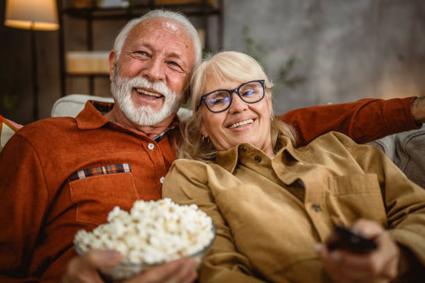 istock senior couple enjoy while watch television and sit on sofa 2190118210