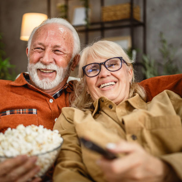 istock senior couple enjoy while watch television and sit on sofa 2190118249