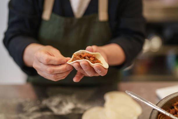istock Korean woman folding dumplings in kitchen. 2190118389