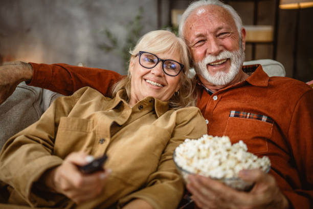 istock senior couple enjoy while watch television and sit on sofa 2190119071