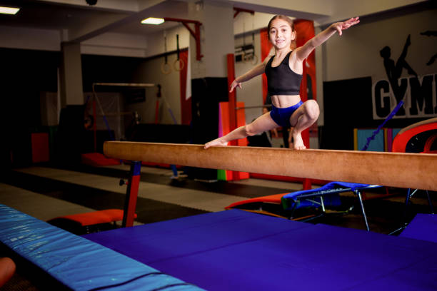 istock Young Gymnast Performing Split Balance on Beam in Gym 2190122002
