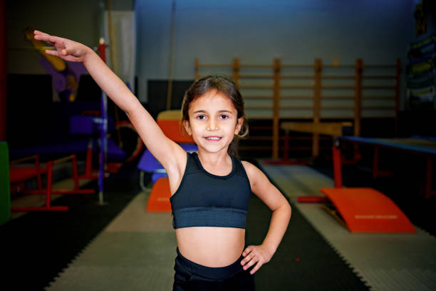 istock miling Girl at Gymnastics Training with Beam and Trampoline in Background 2190122261
