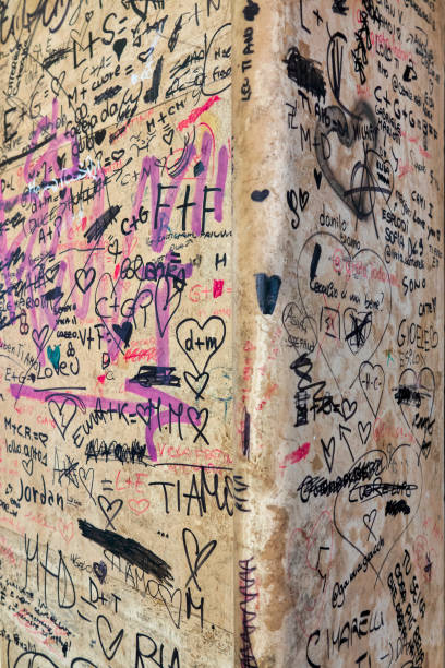 A wall in a neighborhood park covered by colorful graffiti.