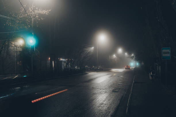 istock Foggy misty night. Road illuminated by street lights 2190127728