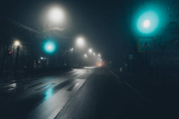 istock Foggy misty night. Road illuminated by street lights 2190127732