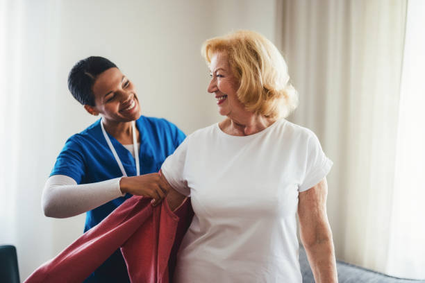 istock Nurse Assisting Elderly Woman With Clothing in Warm and Friendly Setting 2190128633