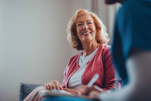 istock Smiling Elderly Woman Engaging Warmly with a Caregiver in a Cozy Setting 2190128641