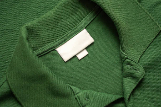 istock Blank white laundry care clothes label on green shirt fabric texture background 2190131936