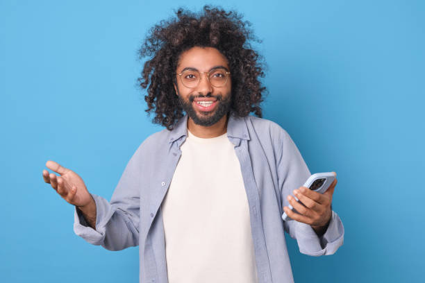 istock Joyful Man Expressing Excitement With Phone Against a Bright Backdrop 2190148676