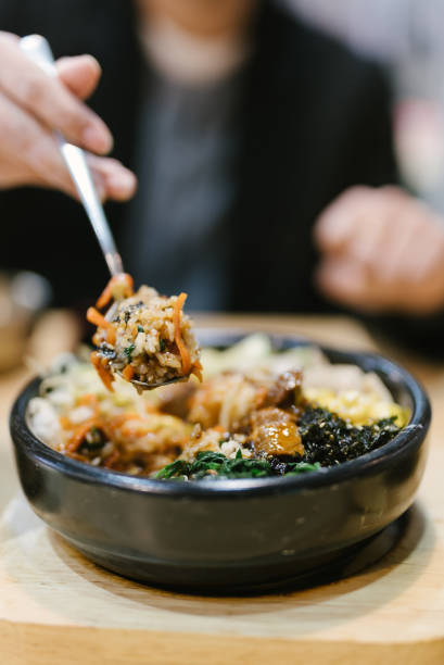 Bibimbap, rice and kimchi, vegetables, eggs and beef served in a stone casserole, South Korea's most famous fast food dish