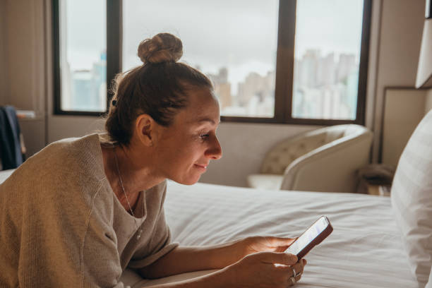 istock Woman Relaxing on Bed Using Smartphone in Modern Apartment 2190151395