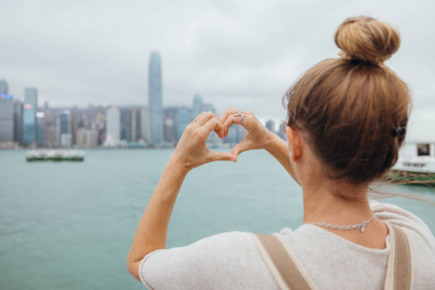 istock Woman Framing City Skyline with Heart-Shaped Hands 2190151985