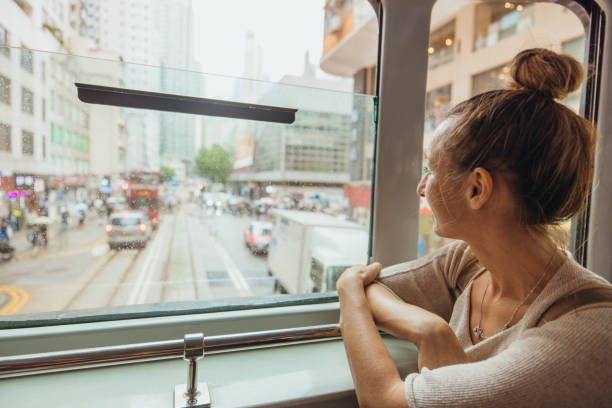 istock Woman Admiring Cityscape from Tram Window in Urban Setting 2190152924