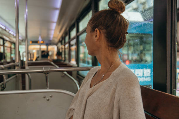 istock Woman Riding Alone on a City Bus Glancing Outside 2190152944