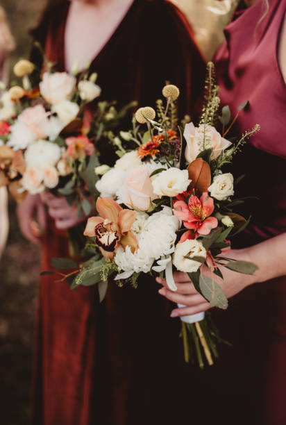 istock Bridesmaids at wedding ceremony with autumn colored flowers 2190153951