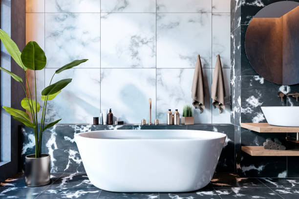 istock Elegant modern bathroom interior with marble walls and sleek white bathtub, featuring natural light, a mirror, and decorative plants. 3D Rendering 2190159170