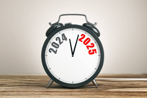 istock Alarm clock showing transition from 2024 to 2025 on a wooden surface, symbolizing time, change, and new beginnings. 3D Rendering 2190159201