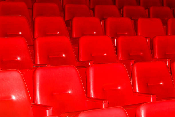 red chairs in front of a metallic wall with window,