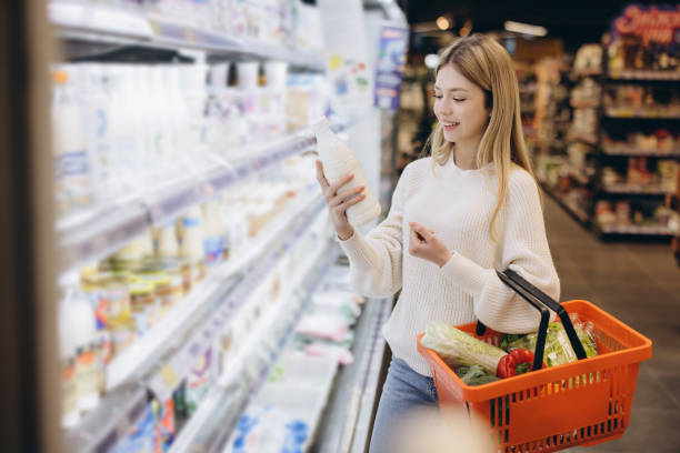 istock Customer choosing milk bottle in supermarket dairy section 2190169105