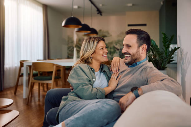 istock Happy couple talking while relaxing on the sofa at home. 2190169123