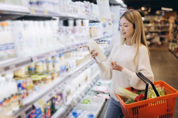 istock Customer choosing milk bottle in supermarket dairy section 2190169129