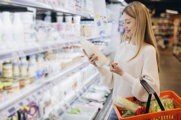 istock Customer choosing milk bottle in supermarket dairy section 2190169134