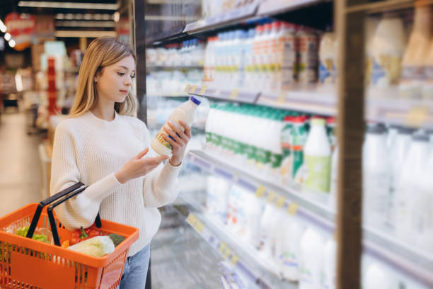 istock Customer choosing milk bottle in supermarket dairy section 2190169273