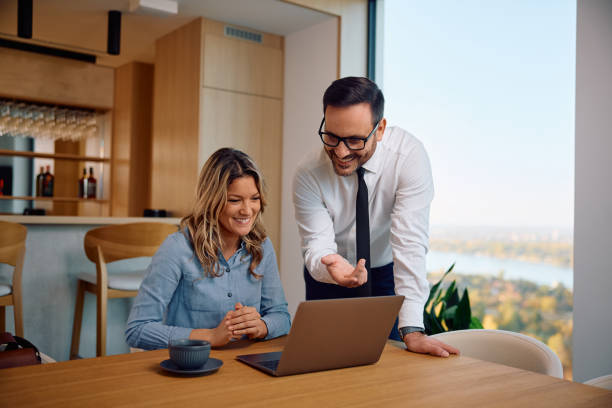 istock Happy colleagues cooperating while working on laptop in the office. 2190169345