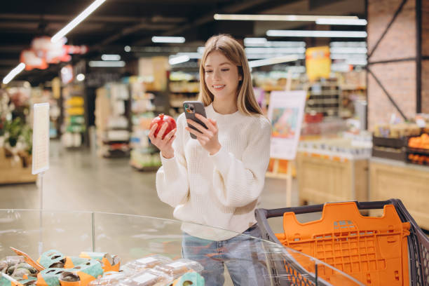 istock Customer using smartphone and choosing pomegranate in supermarket 2190169463