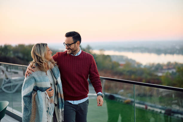 istock Happy couple talking while enjoying on their terrace during autumn day. 2190169472