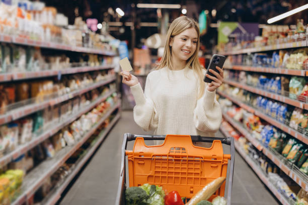 istock Customer using smartphone and credit card in supermarket 2190169762
