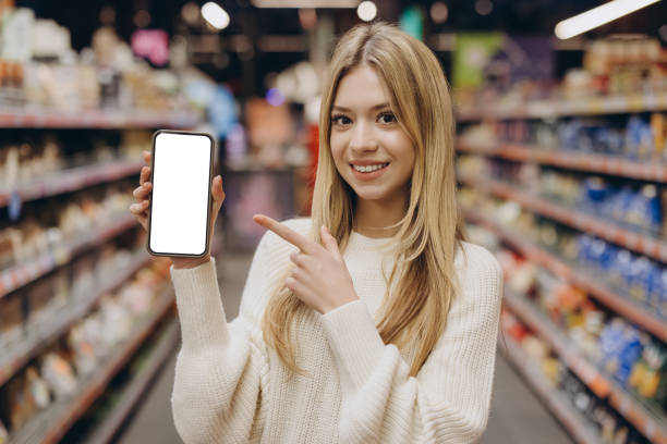 istock Smiling customer showing smartphone with white display in supermarket 2190169790