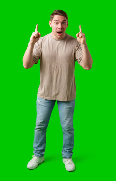 istock Enthusiastic man pointing upwards against a vibrant green background 2190169825