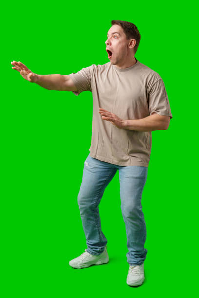 istock Man expressing fear while standing against a bright green background 2190170076