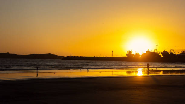 sunset on Essaouira beach, in front of the port, in Morocco