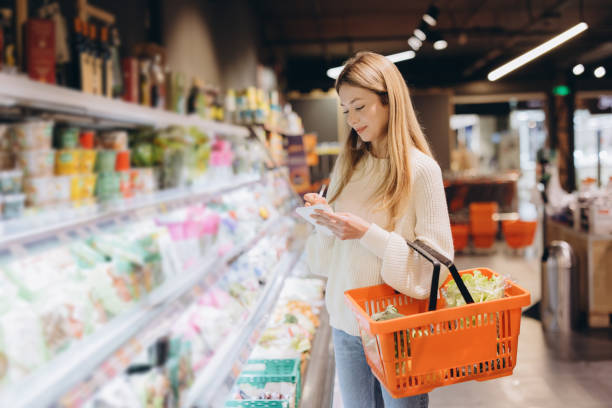 istock Customer taking notes on shopping list while buying groceries in supermarket 2190171006