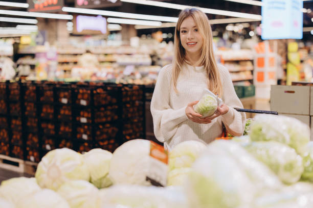 istock Customer choosing fresh lettuce in supermarket produce section 2190171024