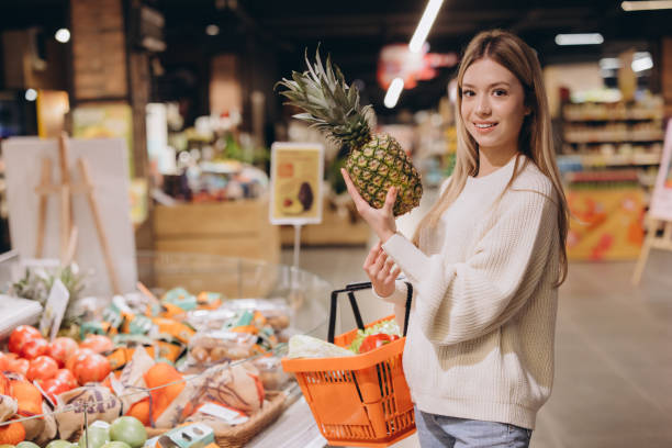 istock Customer choosing pineapple in supermarket fruit and vegetable section 2190171188