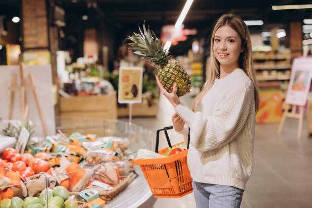 istock Customer choosing pineapple in supermarket fruit and vegetable section 2190171189