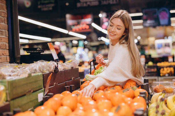 istock Woman choosing persimmon fruit at grocery store 2190171227