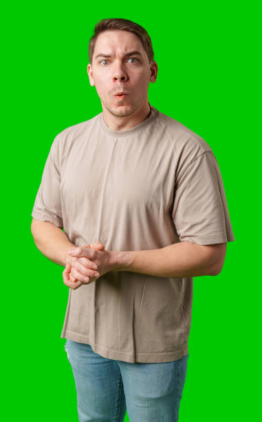 istock Surprised man standing in front of a bright green background 2190172241