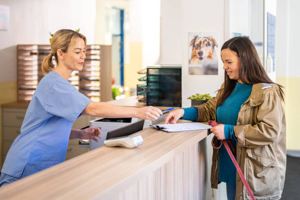 istock Female Veterinary Receptionist Assisting Mature Woman with Forms 2190173663