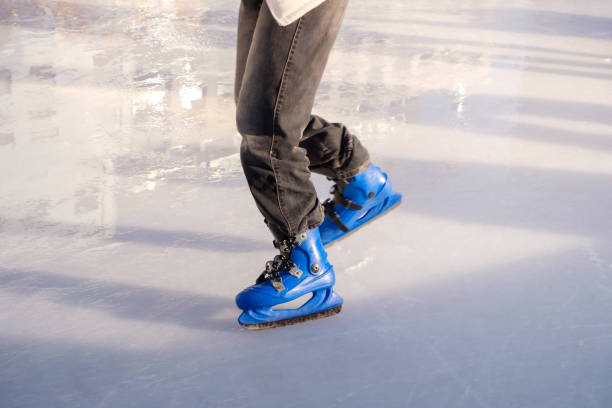 A woman figure skating on the ice of a frozen lake.