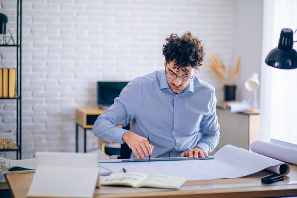istock Engineer man working in the office, drawing and planning the construction project. 2190175149