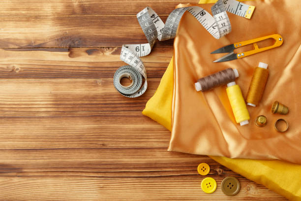 istock Crafting essentials arranged on golden satin fabric with sewing tools and colorful buttons scattered around 2190177673