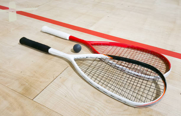 istock Two rackets and two squash balls lie on the parquet floor. Horizontal photo 2190178131