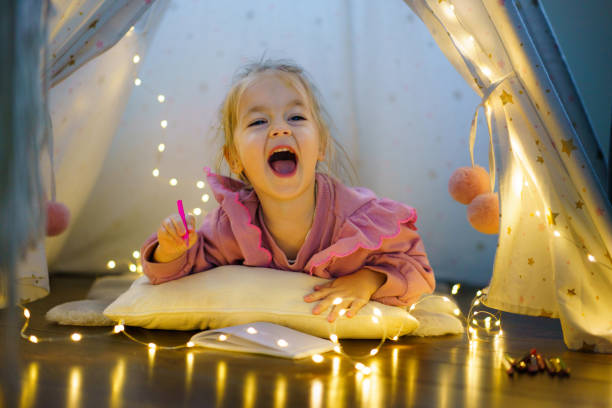 istock Little girl drawing in her tent 2190178730