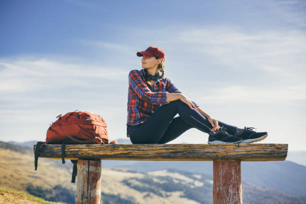 Profile of a hiker resting and breathing fresh air sitting in a rock in the mountain a foggy day