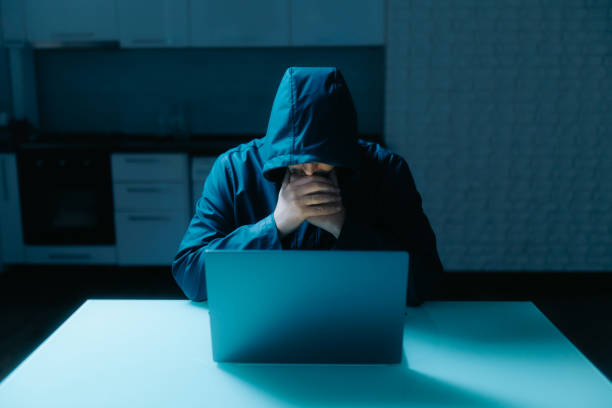 istock Modern Cyber Threat Hooded Hacker Sitting at Kitchen Table at Home 2190180718