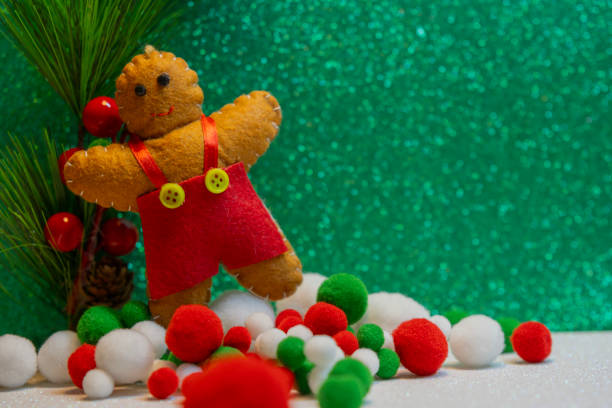 Gingerbread cookie doll and colorful snow over on green glitter background. Christmas New Year holiday concept.